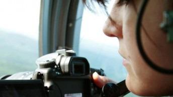 A woman takes a video out of a helicopter