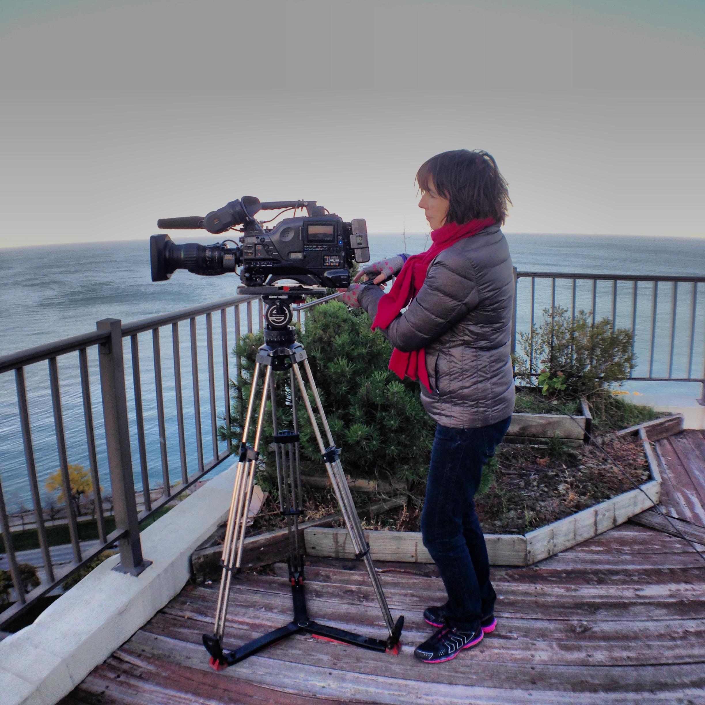 Kim stands at a camera, with her side profile showing.