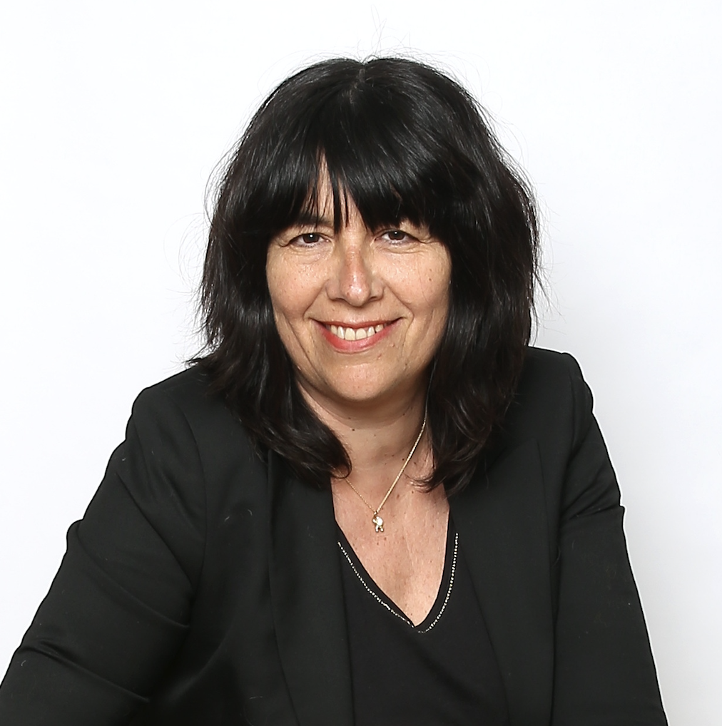 A woman with black hair smiles at the camera.