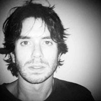 Brian Cassidy looks directly at camera in black and white photo.