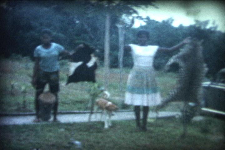 An archival photo of two young girls holding skinned animals.