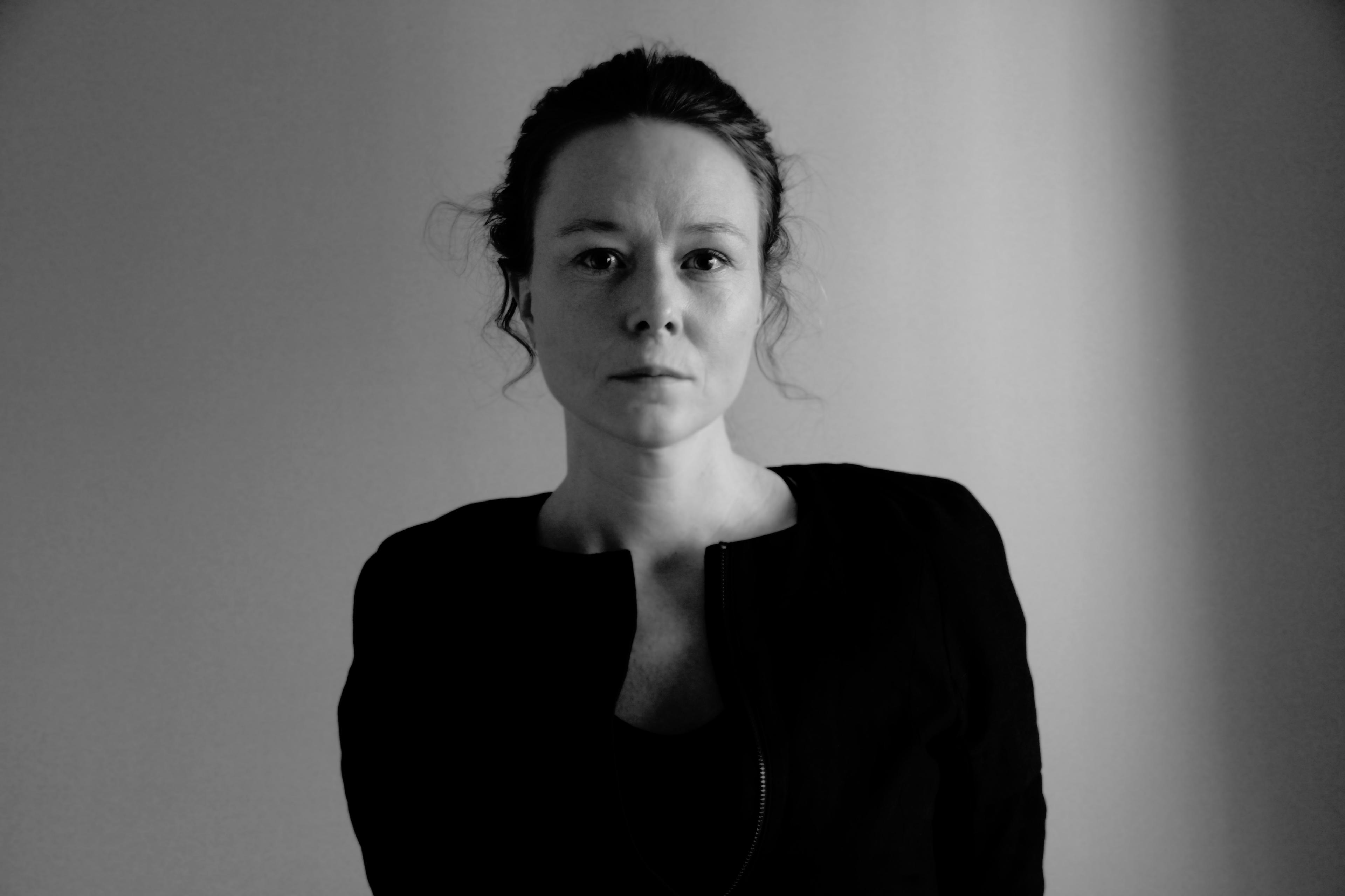 Jennifer Rainsford looks at the camera. Black and white portrait.