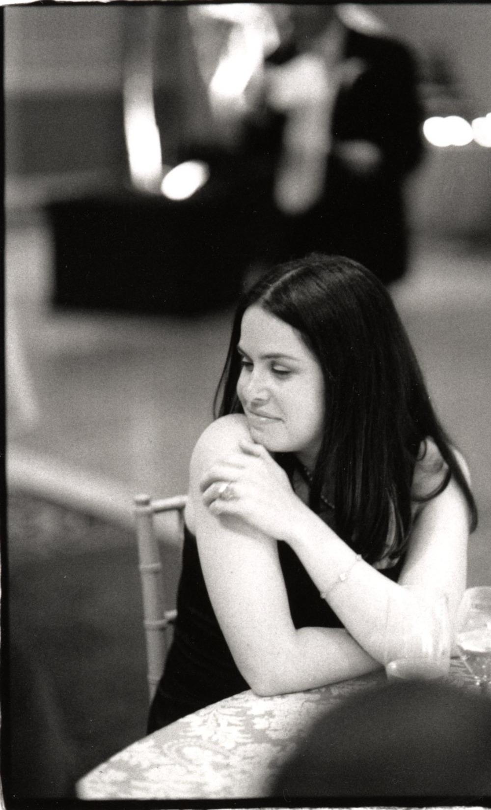 A black and white darkroom print of a woman looking over her shoulder and smiling.
