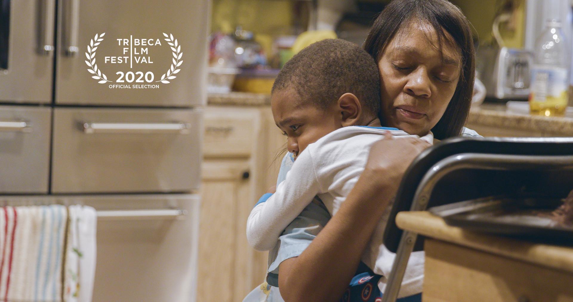 Still from Through the Night. An older person and a child are embracing.